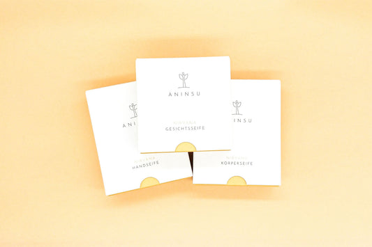 Drei Seifen von Aninsu aufeinander gestapelt: Nirvana Handseife, Nirvana Gesichtsseife und Nirvana Körperseife