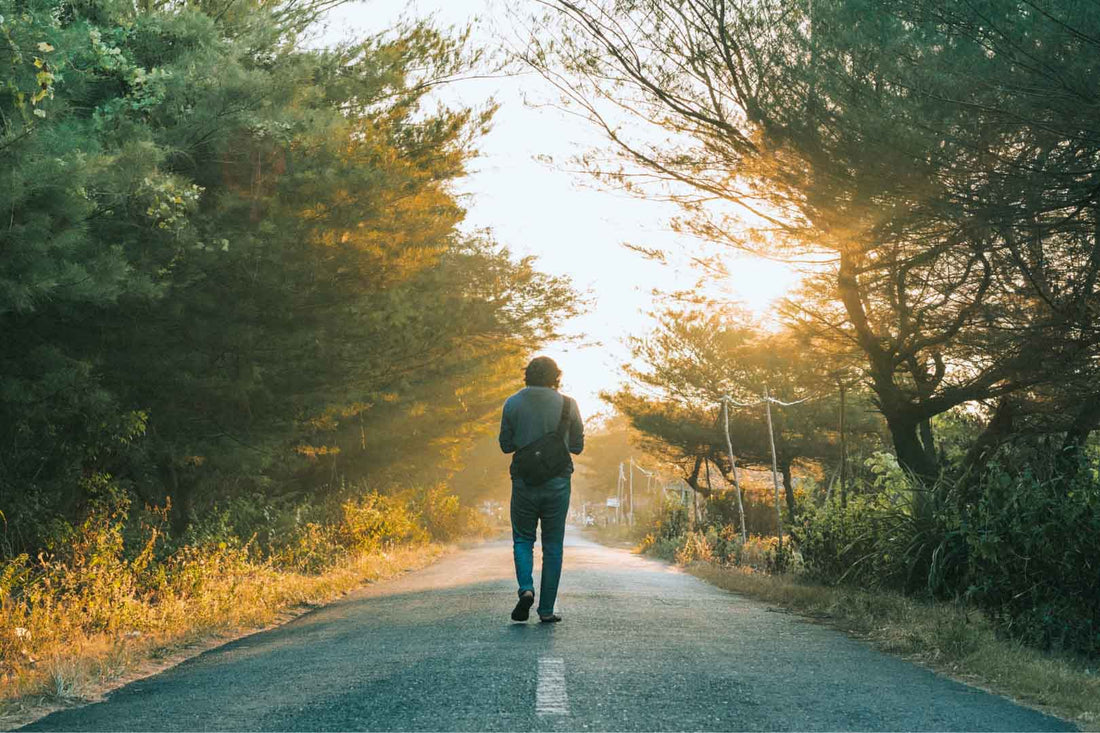 Man spaziert allein auf einer Straße im Wald
