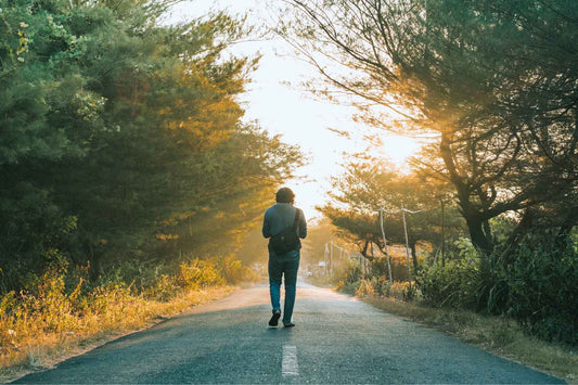 Man spaziert allein auf einer Straße im Wald