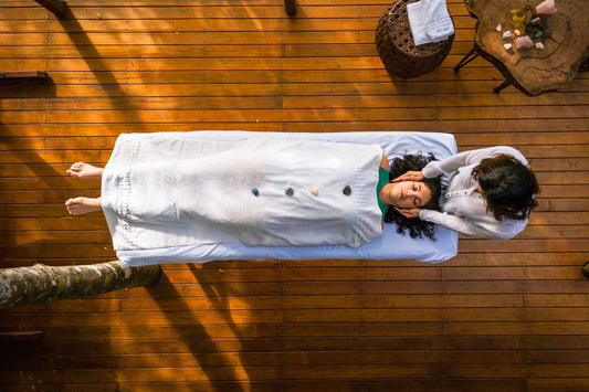 Junge Frau bei einer Reiki-Behandlung durch andere Frau.