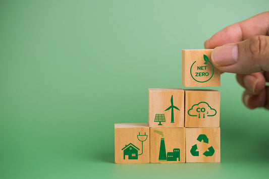 Hand, die Holzwürfel mit Nachhaltigkeitssymbolen stapelt