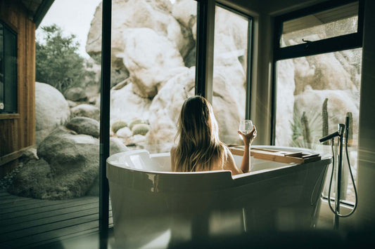 Badezimmer als Rückzugsort: Frau in Badewanne, gläserne Wände, Entspannung