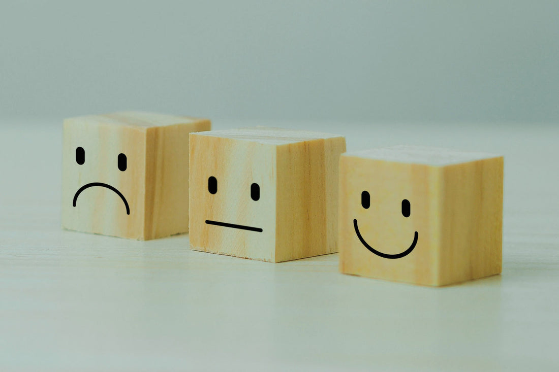 Toxic Positivity - drei Holzwürfel mit verschiedenen Smileys darauf