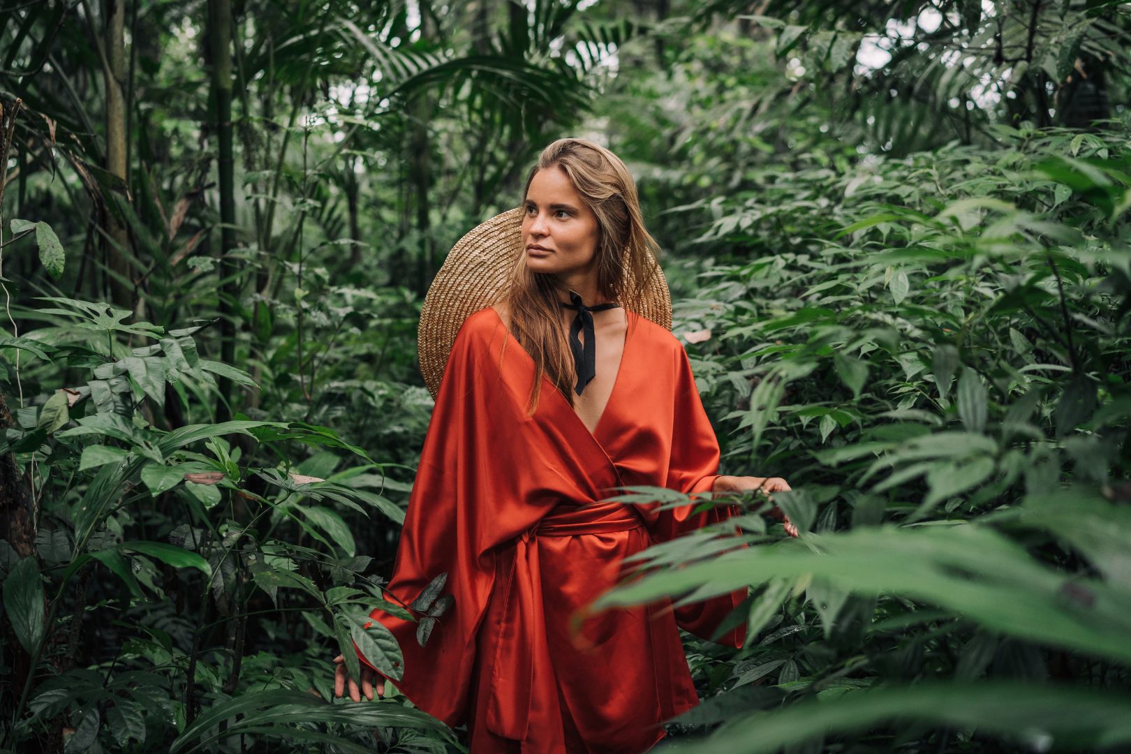 Frau in rotem Kimono aus Baumwollsatin im Dschungel