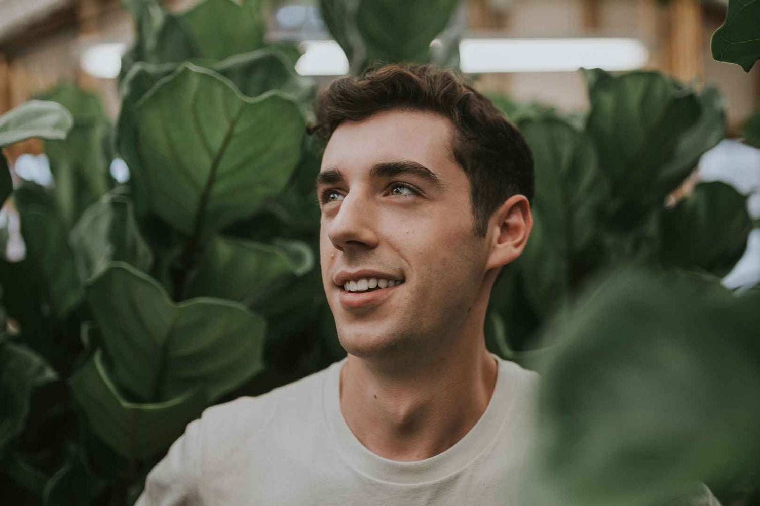 Junger Mann zwischen Pflanzen